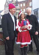 Peter Ainsworth, MP (left), Chris Windridge and one of Santa’s helpers enjoy the artificial snow next to the Asprey Fountain