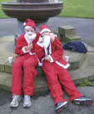 Two scout ‘Santas' rest by the drinking fountain after the run