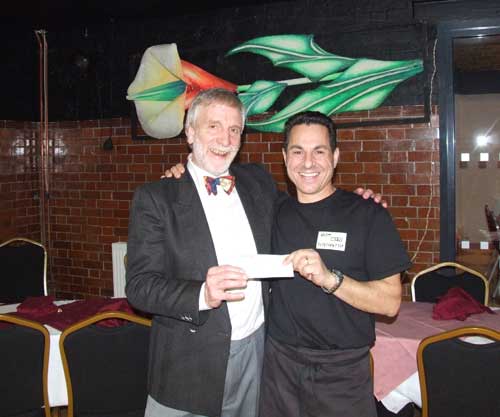 Aldo Floris (right) presenting Dick Moran with a cheque for £660, being the proceeds of the fundraising celebratory lunch.