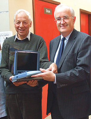 League of Friends Treasurer, Eric Allen, presenting a portable vascular scanner to cardiovascular surgeon, Mr Tom Loosemore to use at the Caterham Dene Hospital.