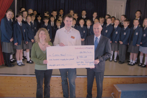 The Warlingham Park School choir is presented with a cheque for £984.68 by Sainsbury's.