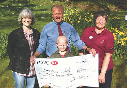 David Knight and Pam Miriam present the cheque for £2,200 to Adam Bird and his mother Alison.