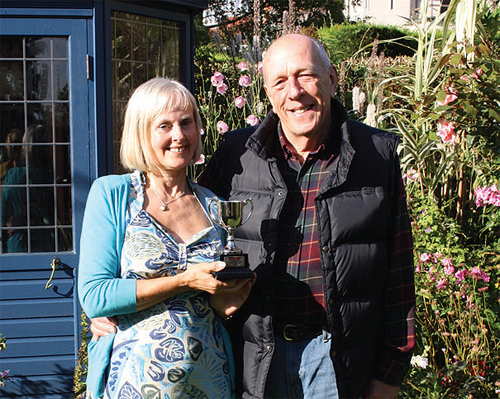 Sue and Geoff Baines in their Burntwood Lane garden with Sue’s Garden News trophy. Photo by Stephanie Bourazanis.