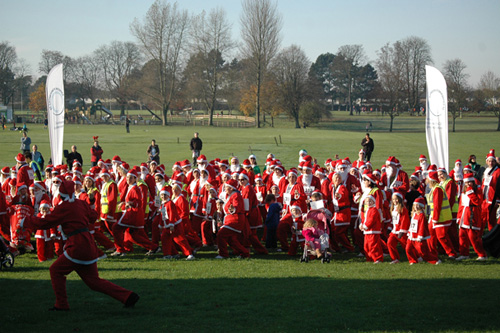  Photo caption:  Santas warm up with a Zumba workout before the start of the race. 